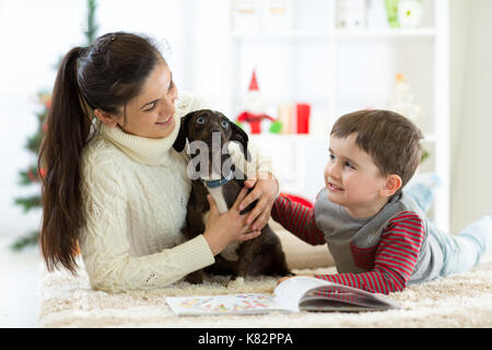 Happy Family enjoying jouant avec nouveau chiot à Noël. Banque D'Images