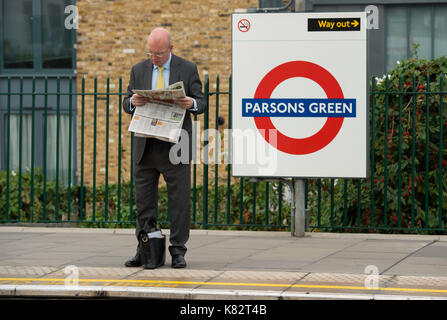 Un frontalier lit un journal sur la plate-forme de la station de métro à parsons green, Londres, après deux personnes ont été arrêtées dans le cadre de l'attentat sur une ligne de train à la station le vendredi. Banque D'Images