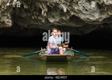 Ninh Binh, Vietnam - 5/6/2016 : un guide touristique et passer au travers d'une grotte inondée sur la rivière ngo dong, près de Tam Coc, village mondial de l'Unesco à trang h Banque D'Images