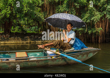 Ninh Binh, Vietnam - 5/6/2016 : a smiling boat guide pagaies sur la rivière ngo dong, près de Tam Coc, village à trang un site du patrimoine mondial de l'dans n Banque D'Images