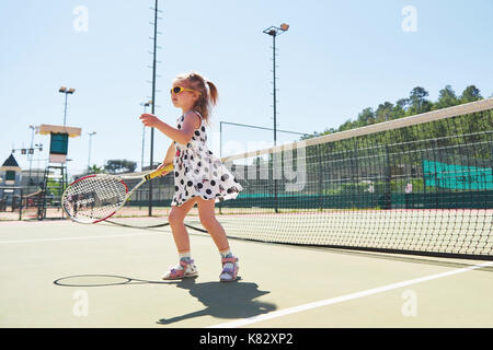 Cute girl playing tennis et posant pour l'appareil photo Banque D'Images