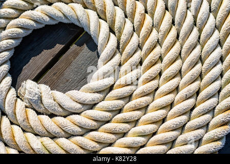 Corde nautique lancé dans une spirale sur la jetée en bois. Banque D'Images