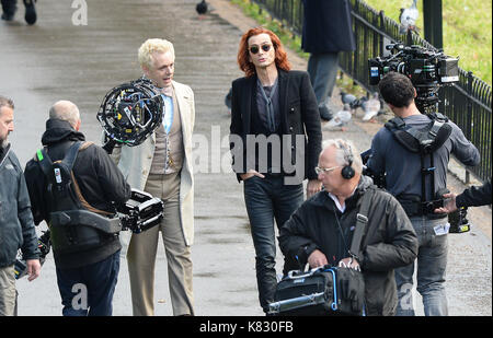 Michael Sheen (robe blanche) avec co-star David Tennant (cheveux roux) comme ils filment une scène de bons présages, basé sur le livre de Terry Pratchett, à St James's Park centre de Londres. Banque D'Images