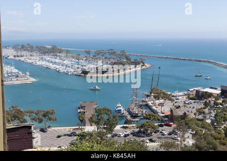 En regardant vers le sud sur la côte de Californie à partir de la falaise au-dessus de Dana Point Harbor avec des bateaux amarrés dans le port de plaisance en toute sécurité derrière le brise-lames Banque D'Images