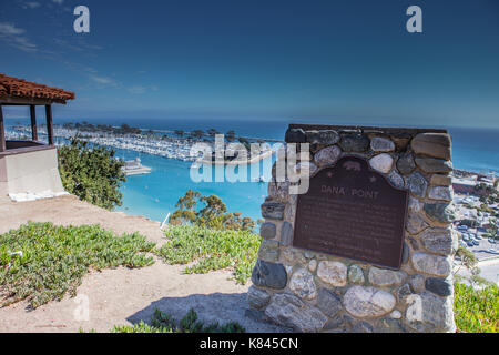 En regardant vers le sud sur la côte de Californie à partir de la falaise au-dessus de Dana Point Harbor avec des bateaux amarrés dans le port de plaisance en toute sécurité derrière le brise-lames Banque D'Images