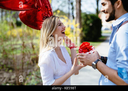 Homme debout et holding white cadeau surprise fort derrière son dos Banque D'Images