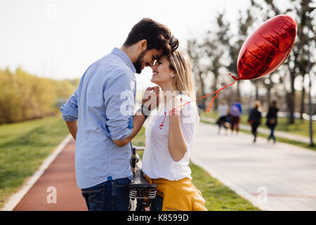 Jeune couple aimant datant tandis que la bicyclette dans la ville Banque D'Images
