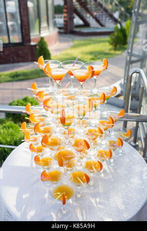 Pyramide de verres lors de célébration. cocktails colorés près. une partie sur le coucher du soleil