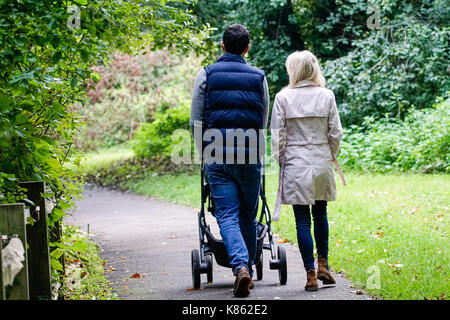 Summers Road, Godalming. 18 septembre 2017. uk météo. La couverture nuageuse a commencé à effacer ce matin sur la home counties, bien que le vent du nord signifiait clairement un sentiment d'automne à la météo. Un couple en train de marcher autour du lac broadwater leur enfant à Godalming, Surrey. Credit : james jagger/Alamy live news Banque D'Images