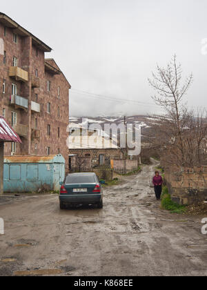 Aparan, petite ville de l'Arménie le long de l'autoroute M3, route de terre avec des trous, des pluies bloc appartement et vue sur les pentes du mont Aragats Banque D'Images