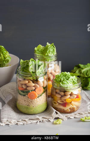 Salade de pâtes et de couscous végétalien dans des pots Mason avec haricots Légumes Banque D'Images