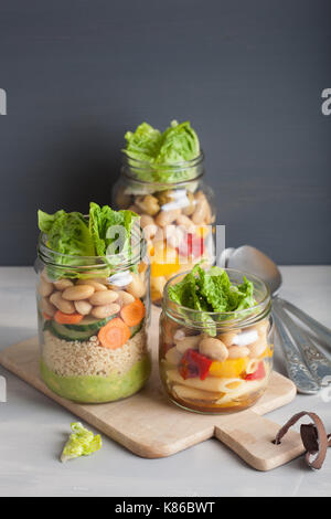 Salade de pâtes et de couscous végétalien dans des pots Mason avec haricots Légumes Banque D'Images