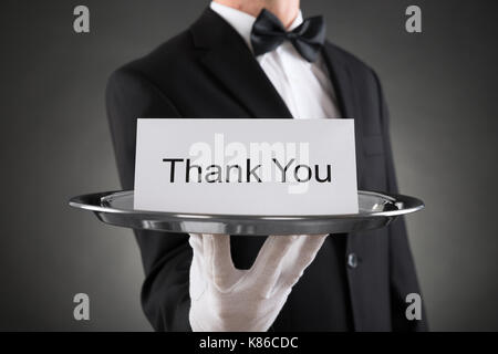 Close-up of waiter holding plaque avec le texte merci sur papier Banque D'Images