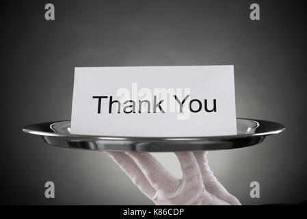 Close-up of waiter holding plaque avec le texte merci sur papier Banque D'Images