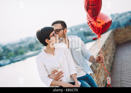 Couple in love holding red baloons cœur sur la Saint-Valentin Banque D'Images