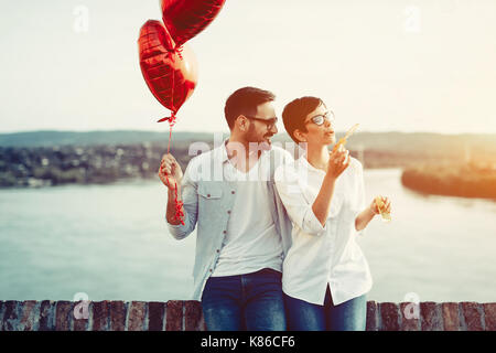 Couple in love holding red baloons cœur sur la Saint-Valentin Banque D'Images