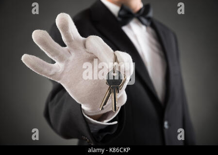 Close-up of waiter holding mains portant des touches gant Banque D'Images