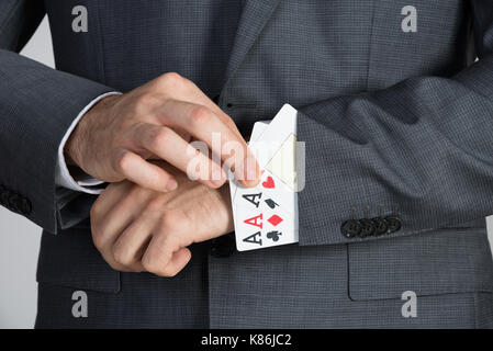 Portrait of businessman dépose les cartes de ace au pouvoir du manchon Banque D'Images