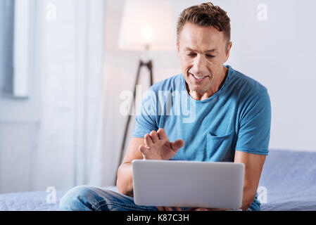 Smiling man faire un appel vidéo sur ordinateur portable Banque D'Images