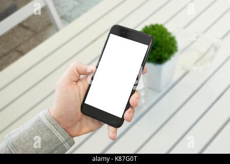 Vitrine de téléphone mobile smart phone noir.. la maquette d'un bureau en bois blanc avec en arrière-plan de l'usine. Banque D'Images