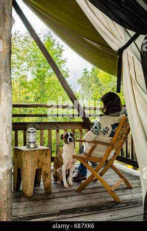 Une femme et son chien glamping à New York. Banque D'Images