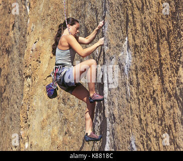 Un jeune, female rock climber scales une falaise verticale à Smith Rock State Park dans le centre de l'Oregon, près de la ville de Terrebonne. Smith Rock est l'un des Banque D'Images