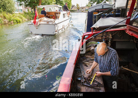 Portrait d'un forgeron travailler à son banc sur un grand classique sur l'eau, tenant un ruban de mesure. Un bateau à moteur en cours. Banque D'Images