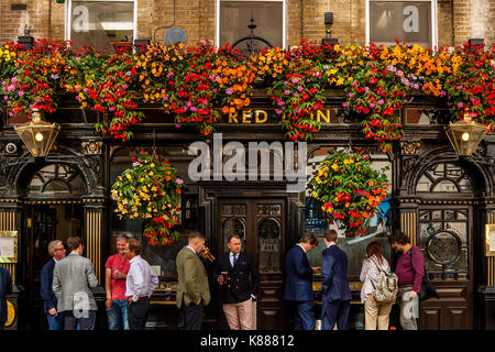 Les Londoniens sirotant une boisson à l'heure du déjeuner à l'extérieur de l'établissement Red Lion Pub Off Jermyn Street, St James's, London, UK Banque D'Images