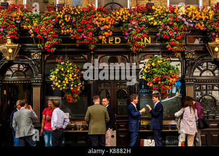 Les Londoniens sirotant une boisson à l'heure du déjeuner à l'extérieur de l'établissement Red Lion Pub Off Jermyn Street, St James's, London, UK Banque D'Images