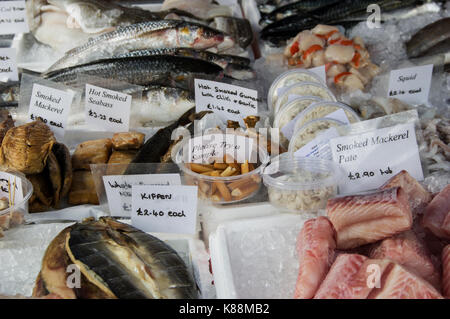 Les poissons, les pétoncles et les filets fumés en vente sur un marché à Londres avec des échantillons gratuits offerts à déguster Banque D'Images