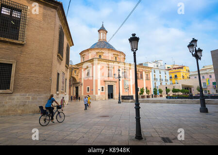 Valencia Espagne plaza, vue d'une femme à vélo à travers la Plaza de la Almoina près du dôme Nuestra Señora de los Desamparados église, Valence. Banque D'Images