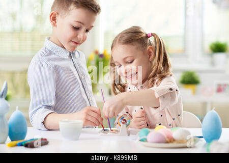 Deux enfants heureux de s'amuser lors de la mise en peinture d'oeufs de Pâques dans le printemps ! Banque D'Images