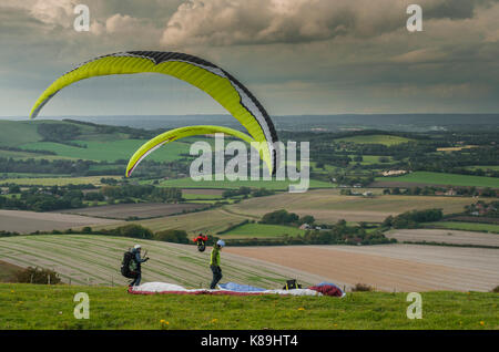 Firle Beacon, Lewes, East Sussex, Royaume-Uni. 18 septembre 2017. Météo britannique. Des pilotes de parapente sur les South Downs du sud de l'Angleterre volent depuis la balise (Marilyn) au vent Du Nord. Nuages épars avec douches mais un après-midi très agréable. Banque D'Images