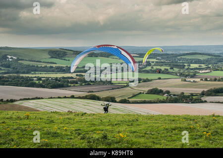 Firle Beacon, Lewes, East Sussex, Royaume-Uni. 18 septembre 2017. Météo britannique. Des pilotes de parapente sur les South Downs du sud de l'Angleterre volent depuis la balise (Marilyn) au vent Du Nord. Nuages épars avec douches mais un après-midi très agréable. Banque D'Images