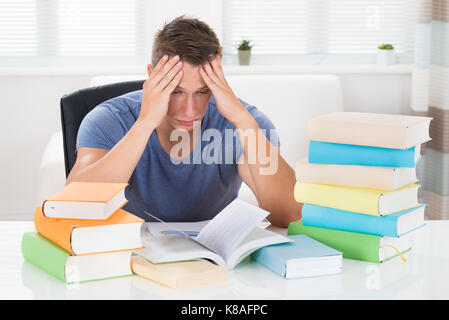 Portrait de jeune homme fatigué d'étudier des livres à 24 Banque D'Images