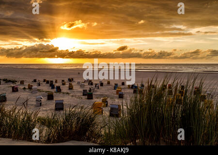 Le coucher du soleil et ciel dramatique au-dessus de la plage sur la mer du Nord, l'île de juist Frise orientale, en Allemagne, en Europe. Banque D'Images
