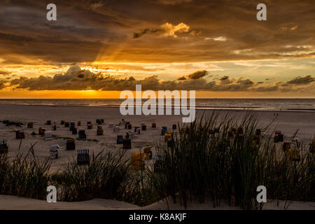 Le coucher du soleil et ciel dramatique au-dessus de la plage sur la mer du Nord, l'île de juist Frise orientale, en Allemagne, en Europe. Banque D'Images