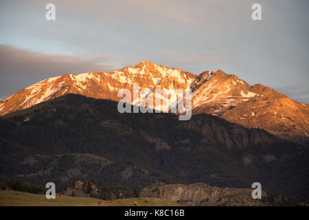 Electric peak au coucher du soleil avec evergreen couverts foothills et une vallée verdoyante à l'avant-plan. Banque D'Images