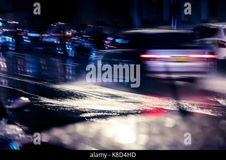 Le trafic de nuit en ville. voitures roulant sur route mouillée lors de fortes pluies. vue brouillée. Banque D'Images