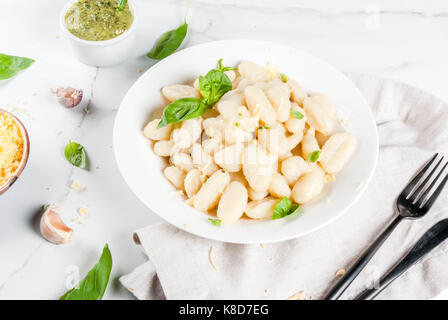 Recette de cuisine italienne, dîner végétalien sain avec gnocchi de pommes de terre. de parmesan râpé, le basilic et le pesto. sur le marbre blanc , copy space Banque D'Images
