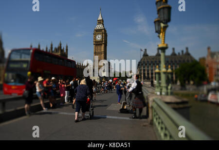 Un touriste occupé rempli Westminster Bridge poster les barrières de protection avec Big Ben et Elizabeth tower à bas avec Tilt Shift effet lentille Banque D'Images