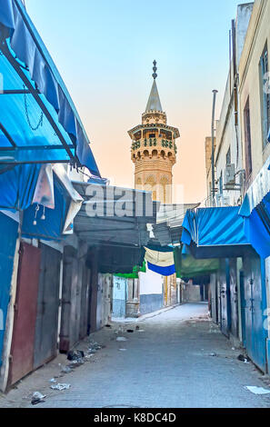 Le minaret de la mosquée youssef dey (al b'chamqiya), première mosquée turc ottoman à Tunis, se lève sur les étals de marché local fermé, la Tunisie. Banque D'Images