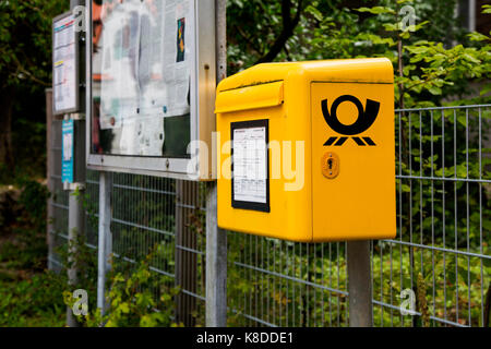 Une boîte mail Deutsche Post à un arrêt d'autobus à Bottmingen, Bavière, Allemagne. Banque D'Images