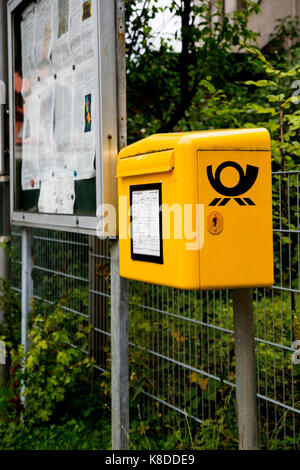 Une boîte mail Deutsche Post à un arrêt d'autobus à Bottmingen, Bavière, Allemagne. Banque D'Images