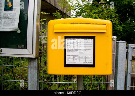 Une boîte mail Deutsche Post à un arrêt d'autobus à Bottmingen, Bavière, Allemagne. Banque D'Images