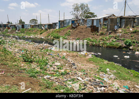 La ligne des baraques taudis rivière Ngong qui est polluée par des déchets, les déchets plastiques et les ordures, Nairobi, Kenya Banque D'Images