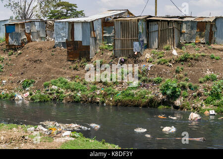 La ligne des baraques taudis rivière Ngong qui est polluée par des déchets, les déchets plastiques et les ordures, Nairobi, Kenya Banque D'Images