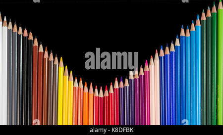 Crayons de couleur isolé sur fond noir dans la formation de vagues. tiré sur close-up Banque D'Images