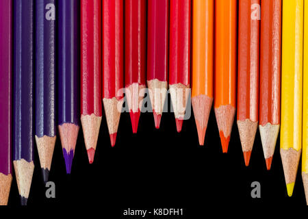 Crayons de couleur isolé sur fond noir dans la formation de vagues. tiré sur close-up avec des crayons vers le bas Banque D'Images