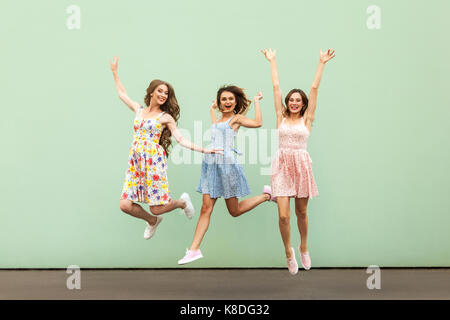 Quartiers young adult woman's de saut et les mains. à la caméra et à sourire à pleines dents. Piscine tourné sur fond vert. Banque D'Images